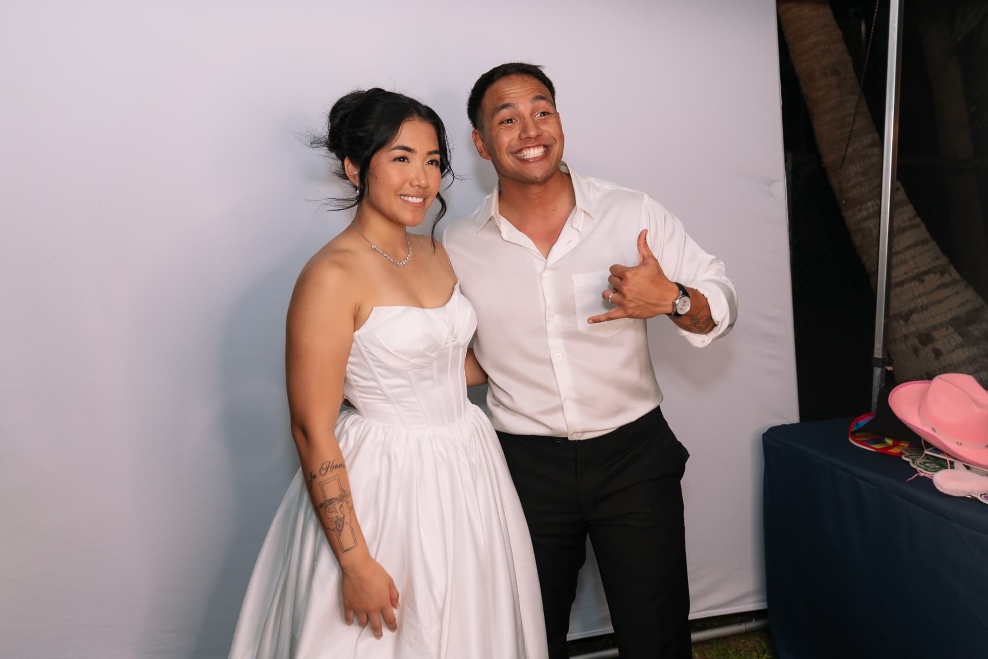 Newlyweds posing with props at the photobooth