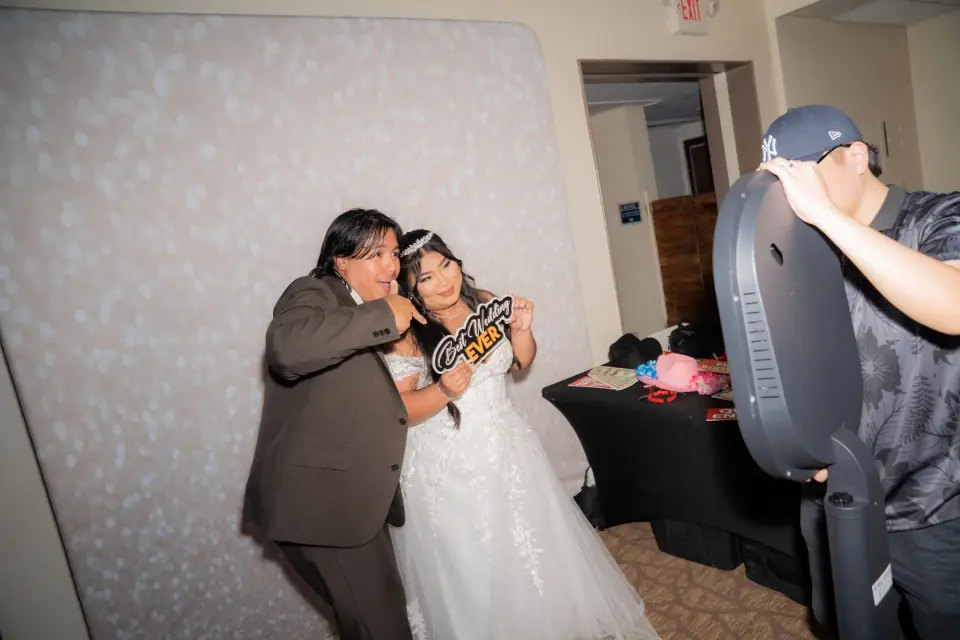 Stel Star photobooth host helping a wedding couple pose with props