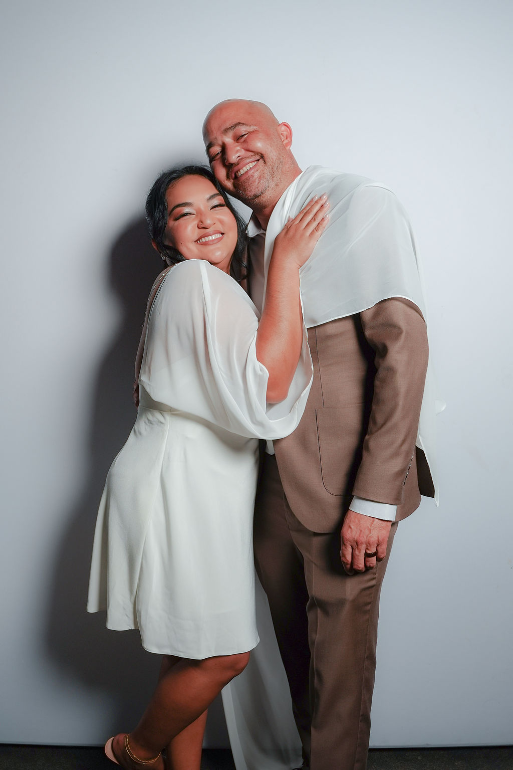Bride and groom sharing a playful portrait booth moment