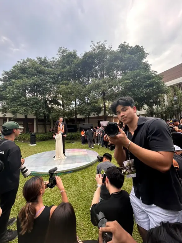 Stel Star photographer photographing a couple on an outdoor stage while other photographers work around him