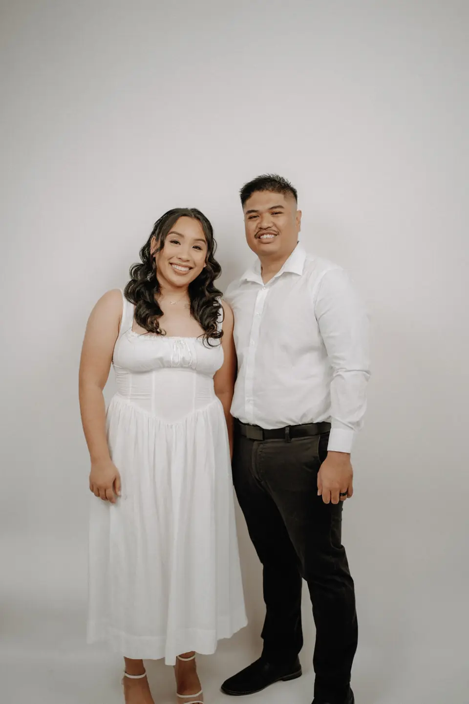 Engaged couple dressed in white for their studio session
