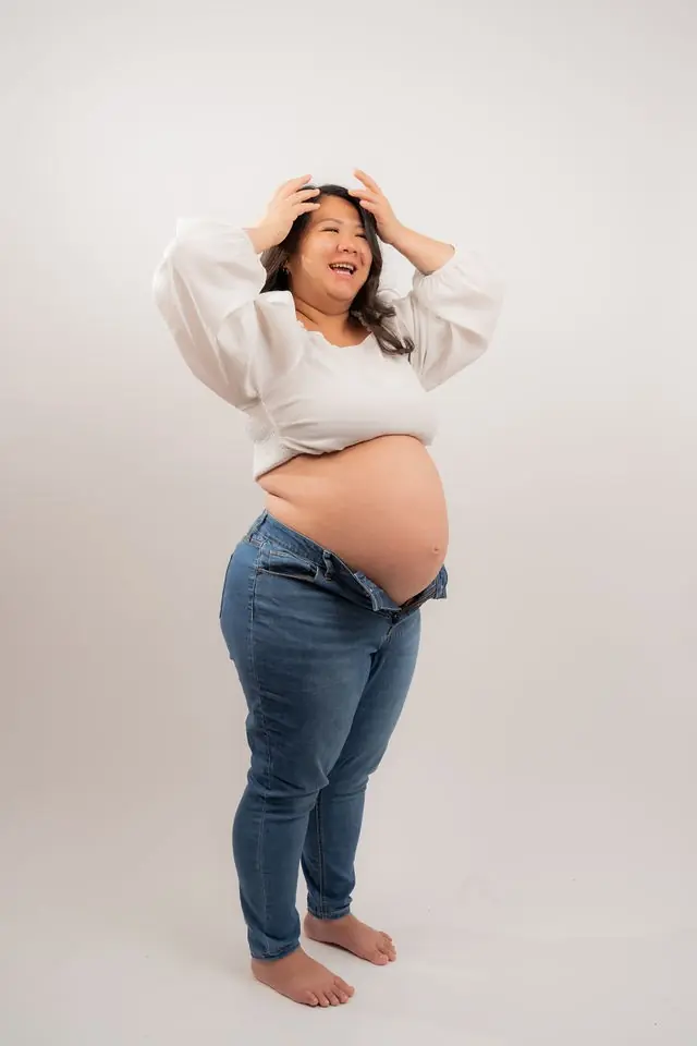 Joyful maternity portrait against a clean studio backdrop
