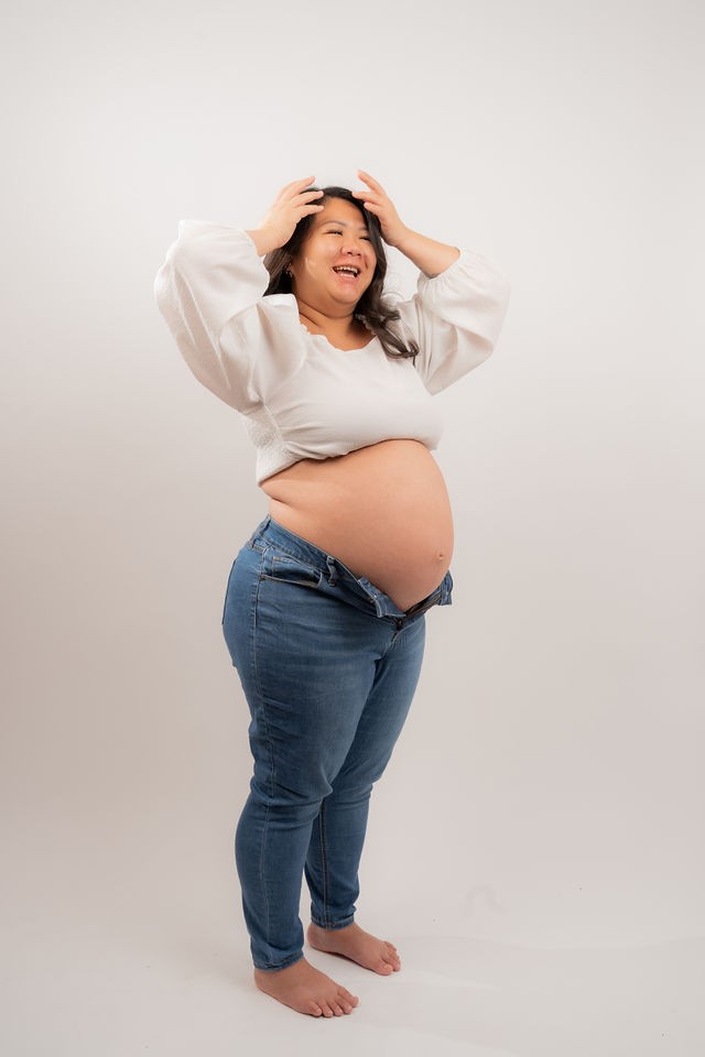 Joyful maternity portrait against a clean studio backdrop