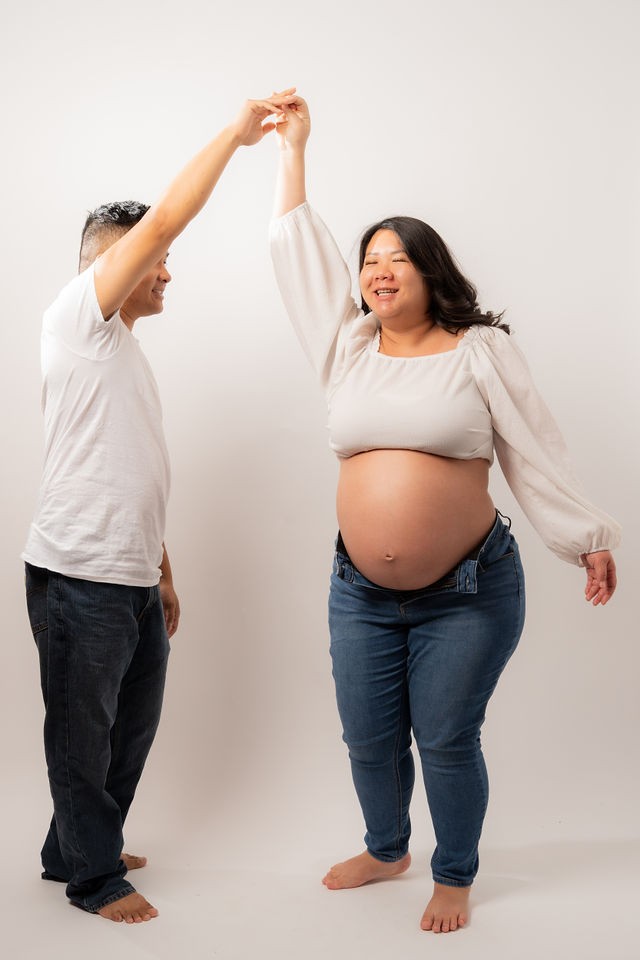 Expecting couple dancing during their studio maternity session