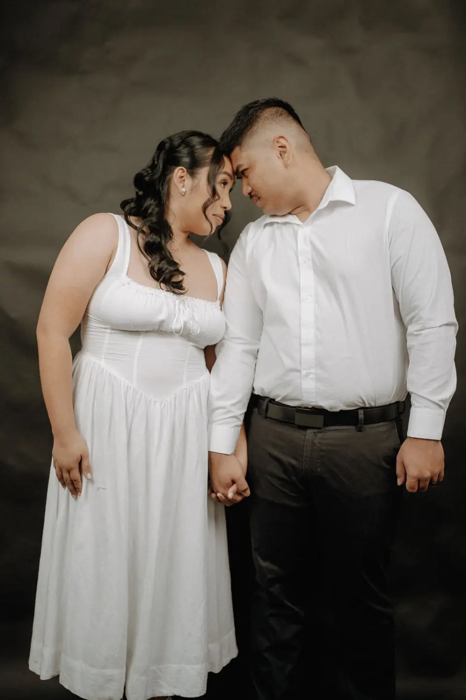 Engaged couple sharing a quiet studio portrait